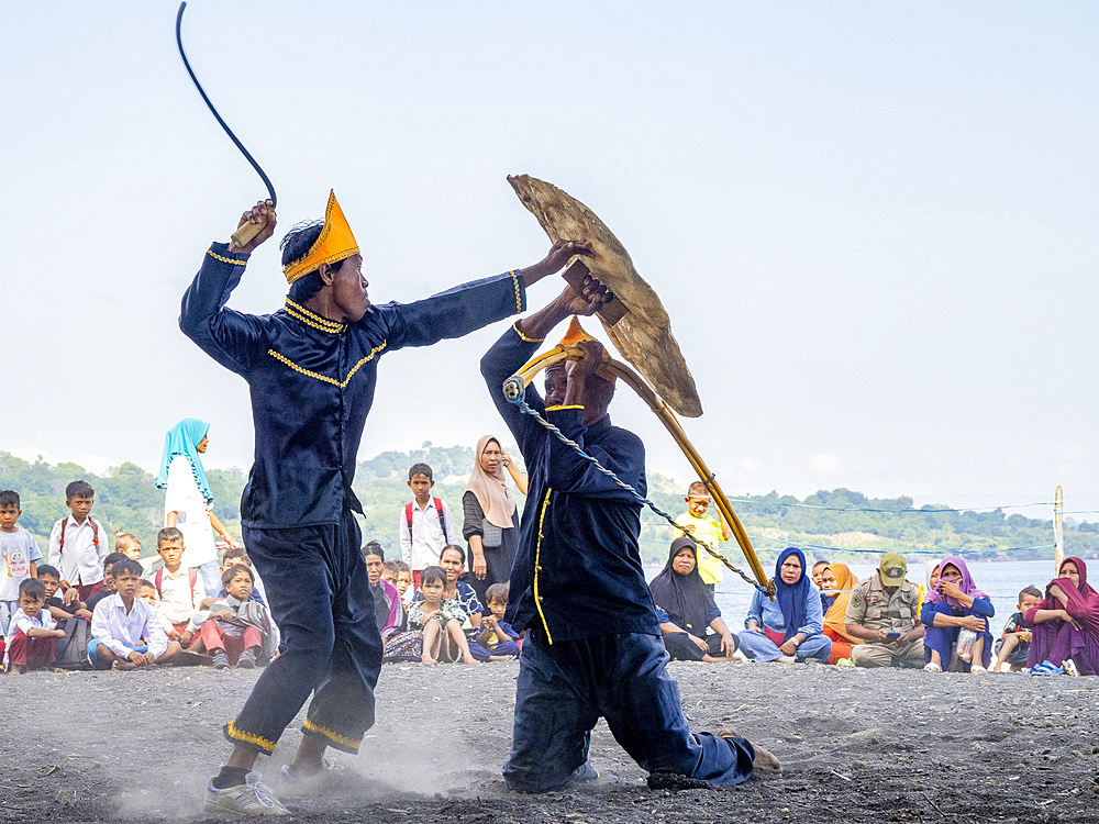 Ceremonial mock fighters perform a ritualized battle with whip, shield, and bow on Sumbawa Island, Indonesia.