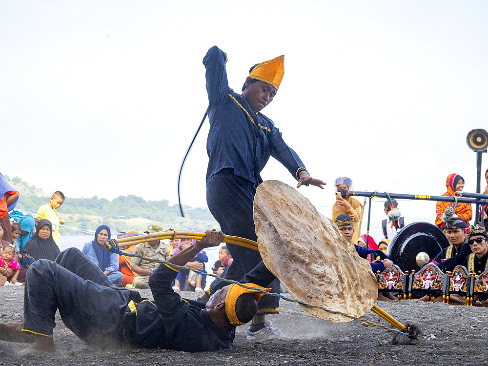 Ceremonial mock fighters perform a ritualized battle with whip, shield, and bow on Sumbawa Island, Indonesia.