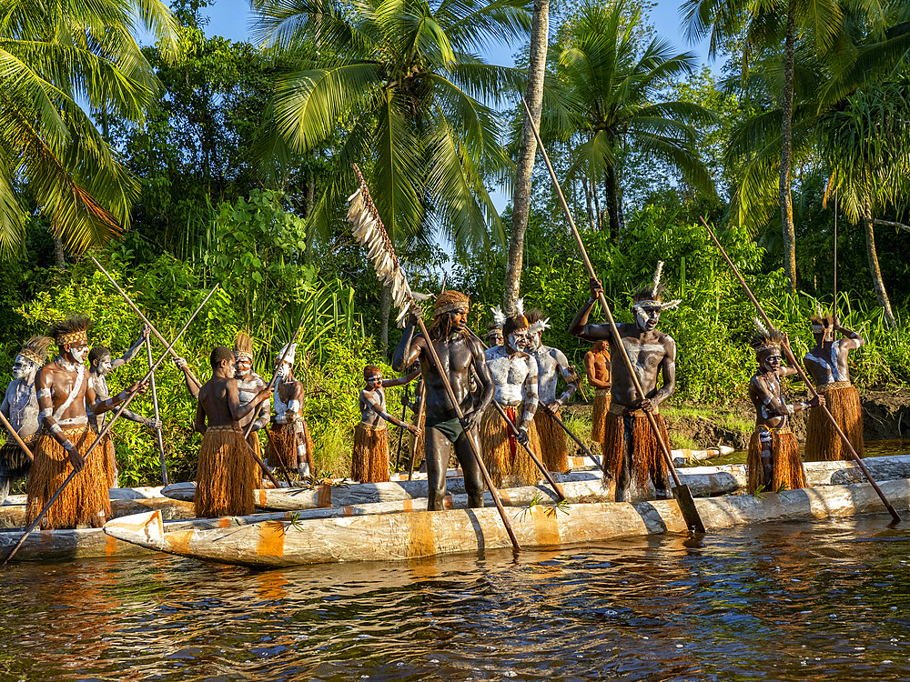Male paddlers from the village of Per perform in a ritualistic greeting ceremony, Asmat Region, Papua, Indonesia.