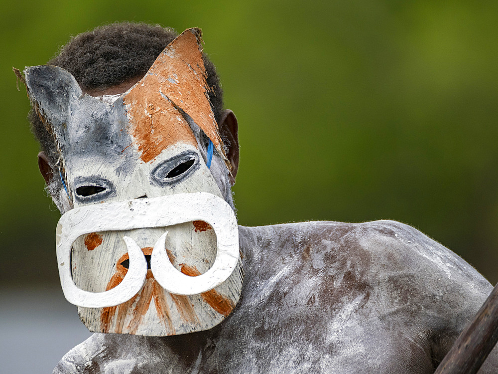 Male paddler from the village of Uwus perform in a ritualistic greeting ceremony, Asmat Region, Papua, Indonesia.