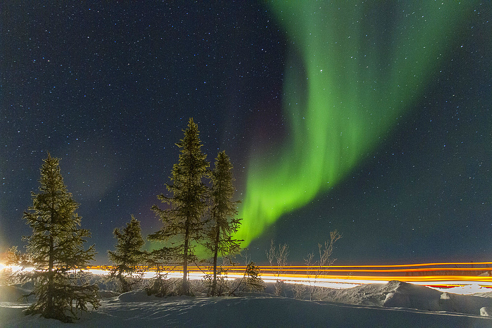 Long exposure of Jeep lights and Aurora Borealis, on the Great Slave Lake, Northwest Territories, Canada.