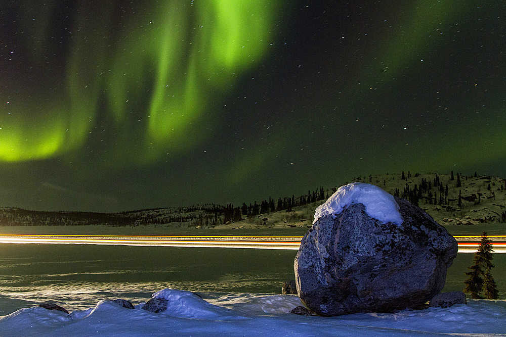 Long exposure of Jeep lights and Aurora Borealis, on the Great Slave Lake, Northwest Territories, Canada.