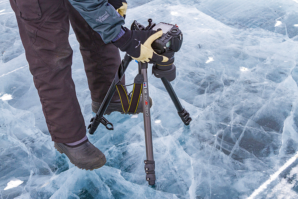 Canadian photographer Gilles Pucheu on the frozen solid Great Slave Lake, Northwest Territories, Canada.