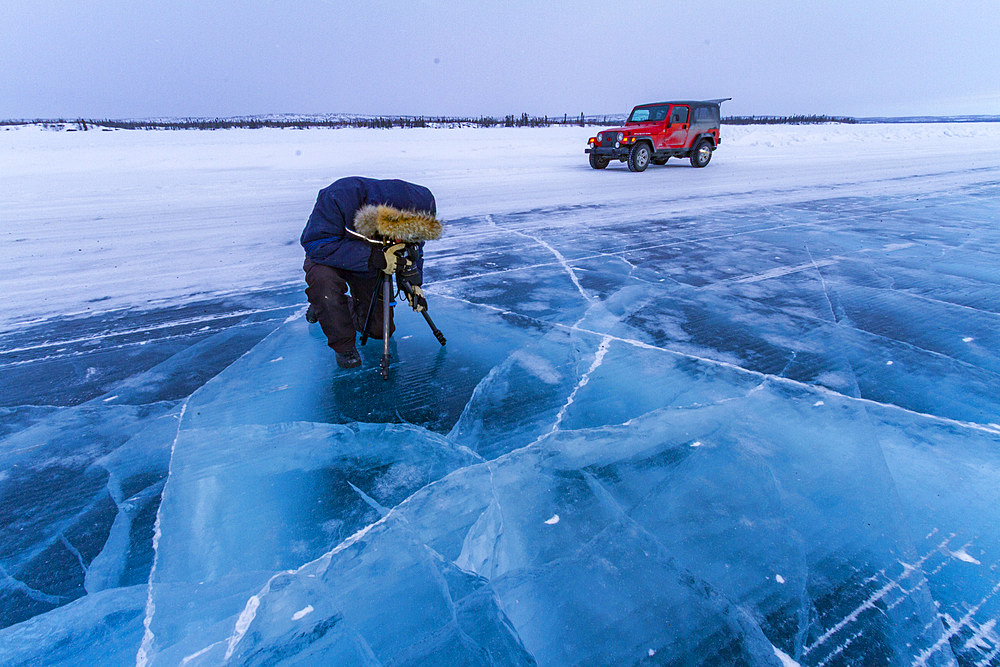 Canadian photographer Gilles Pucheu on the frozen solid Great Slave Lake, Northwest Territories, Canada.