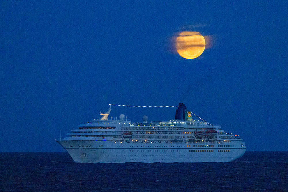 A cruise ship under a full moon in the Beagle Channel near Ushuaia, Tierra del Fuego, Argentina.