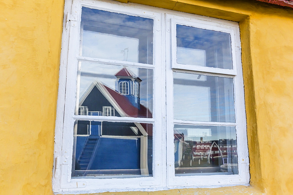 Church reflected in brightly painted house window in Sisimiut, Greenland, Polar Regions