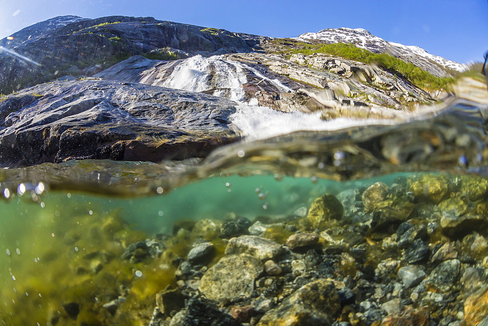 Above and below view of ice melt waterfall cascading down in Svartisen National Park, Melfjord, Nordfjord, Norway, Scandinavia, Europe