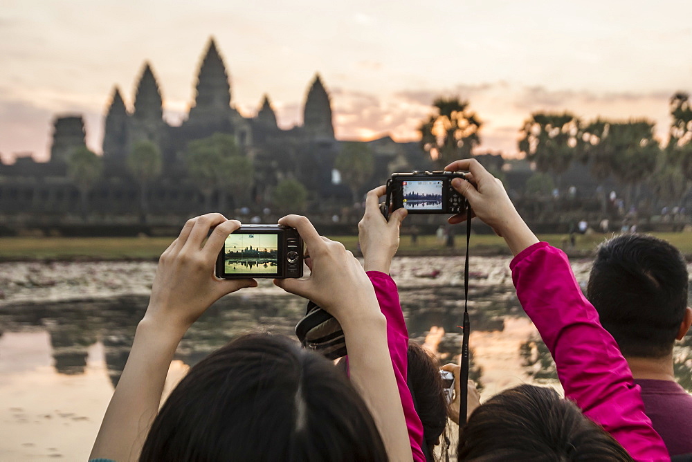 Tourists photographing the sunrise over the west entrance to Angkor Wat, Angkor, UNESCO World Heritage Site, Siem Reap, Cambodia, Indochina, Southeast Asia, Asia