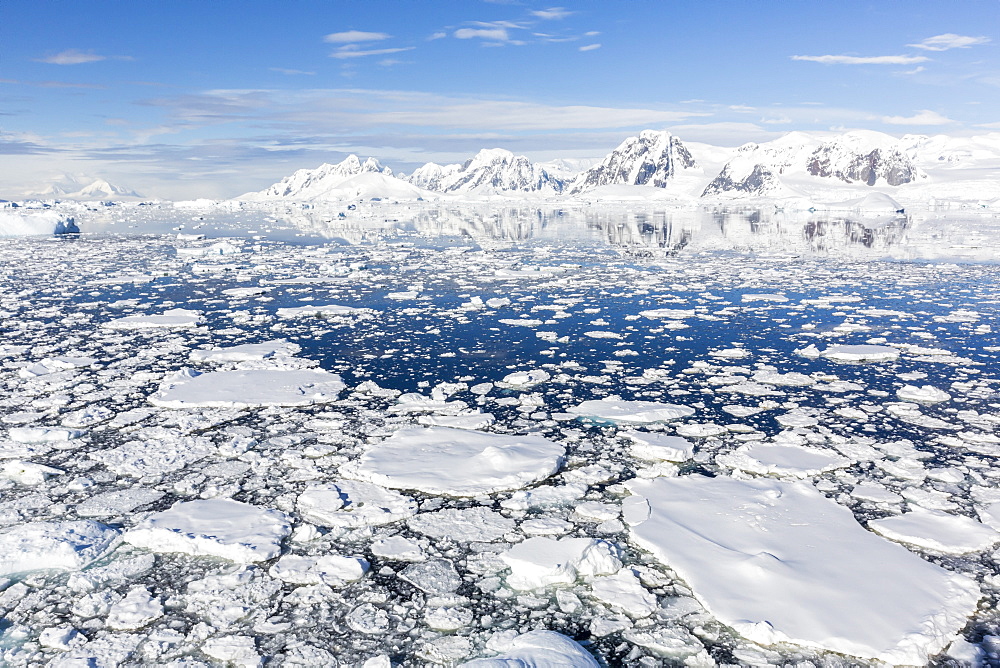 Snow-covered mountains line the ice floes in Penola Strait, Antarctica, Polar Regions