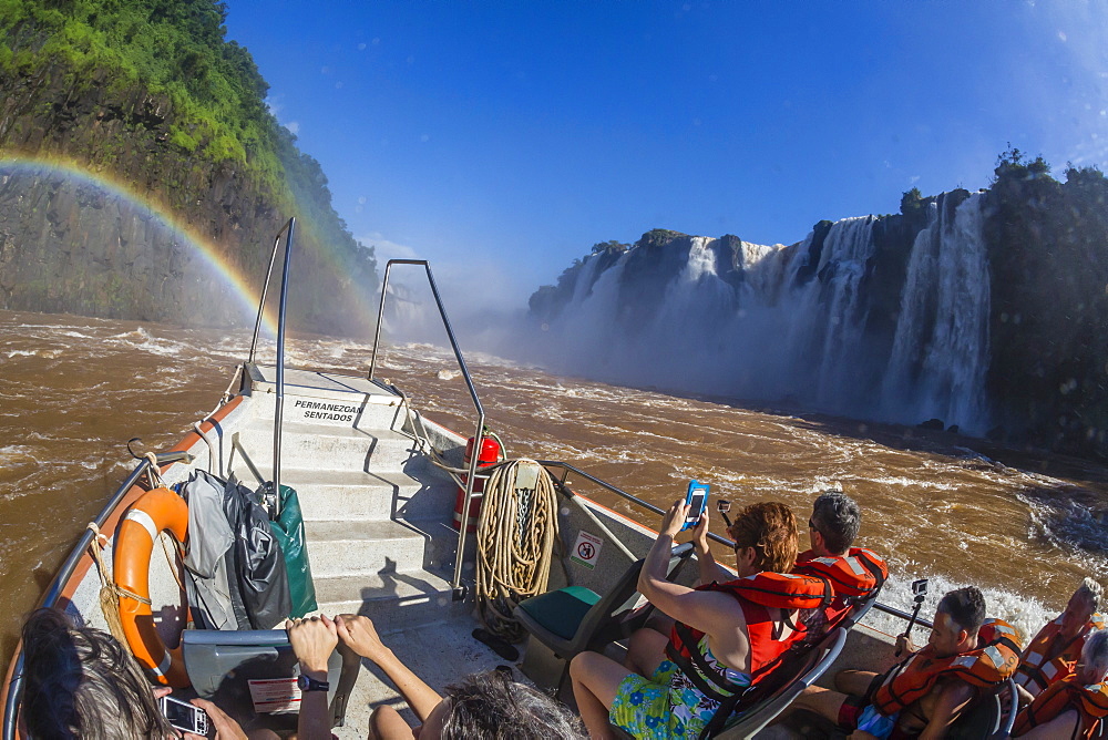 Tourists take a river boat to the base of the falls, Iguazu Falls National Park, UNESCO World Heritage Site, Misiones, Argentina, South America