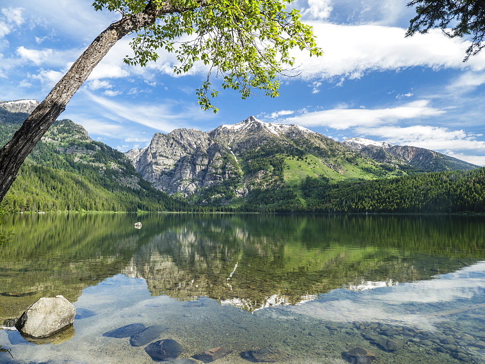 Snow-capped mountains reflected in the calm waters of Phelps Lake, Grand Teton National Park, Wyoming, United States of America, North America