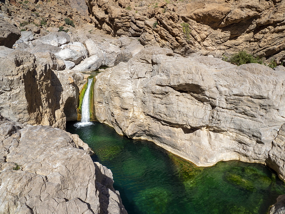 Waterfall dropping in to naturally formed swimming pools in Wadi Bani Khalid, Sultanate of Oman, Middle East