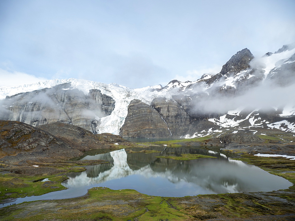 Snow-covered mountains and glacial meltwater lake in Gold Harbor, South Georgia, Polar Regions