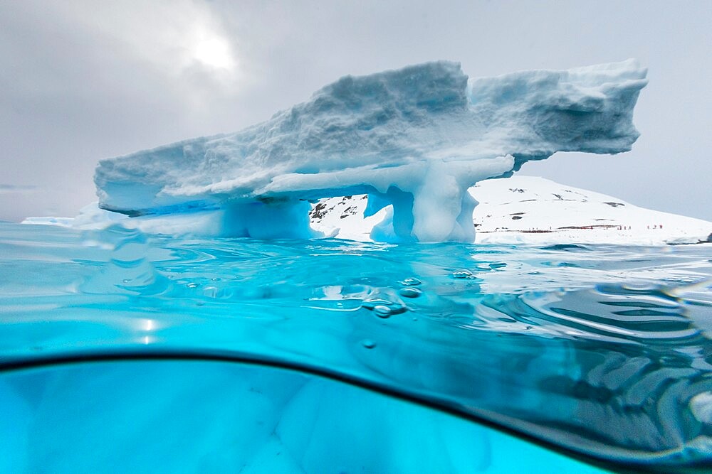 Above and below view of an arch formed in an iceberg at Cuverville Island, Ererra Channel, Antarctica, Polar Regions