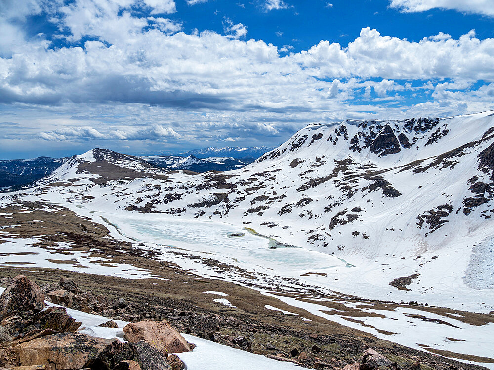 Snow-capped mountains and a frozen lake near Beartooth Pass, Wyoming, United States of America, North America