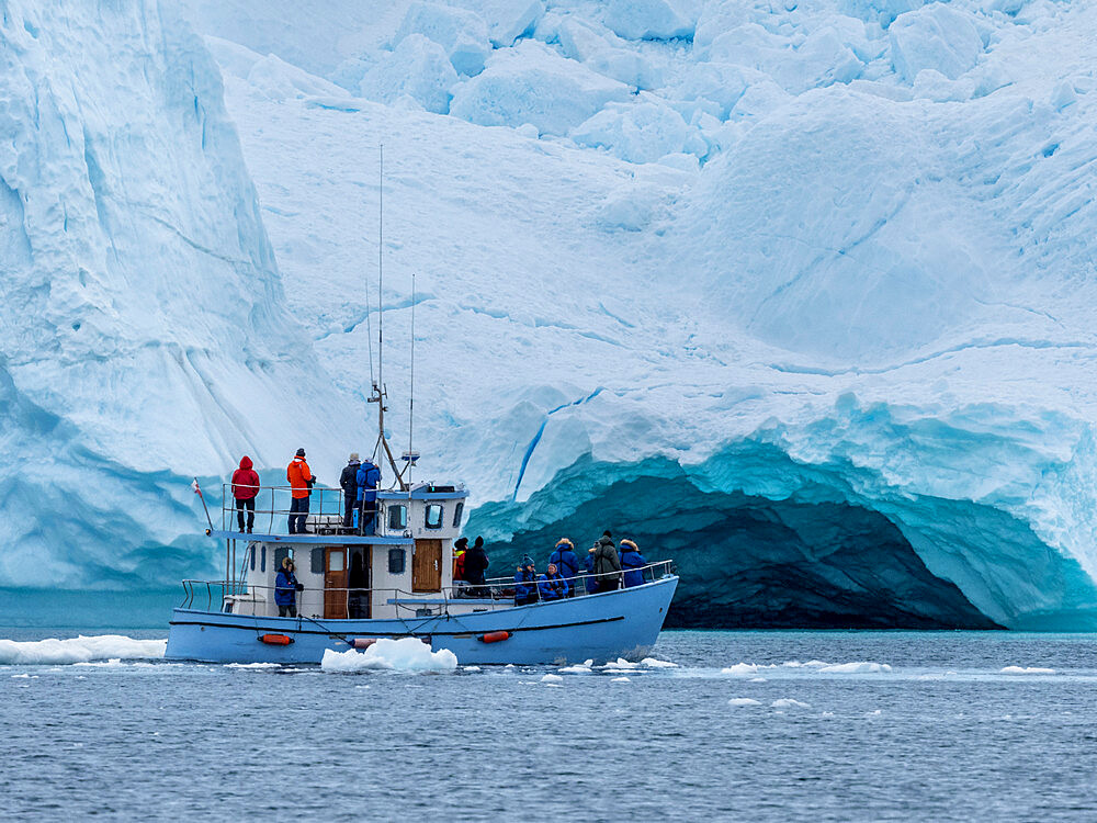 Tourists taking an ice tour in a small boat watching icebergs from the Ilulissat Icefjord, just outside Ilulissat, Greenland, Denmark, Polar Regions