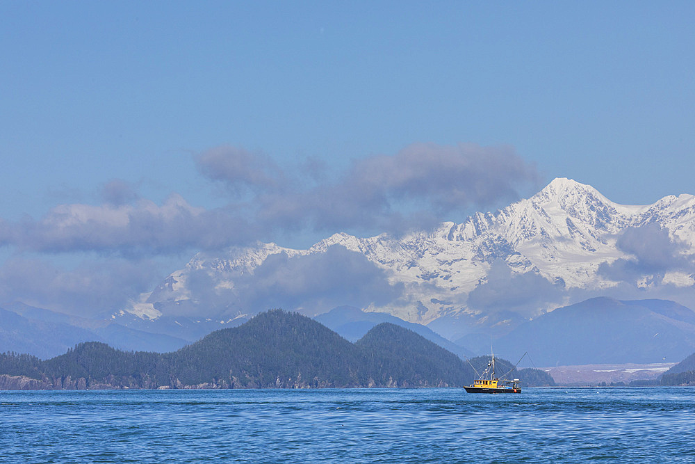 Commercial fishing boat in Inian Pass with the Fairweather Mountains behind, Southeast Alaska, USA.