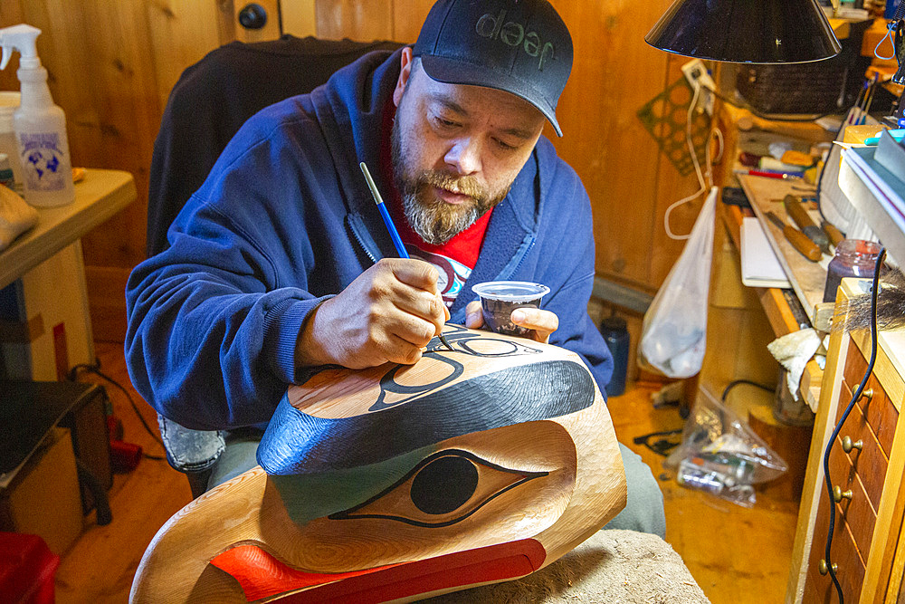 Artisan with traditional mask in Old Massett, G̱aaw in X̱aad kíl, Graham Island, Haida Gwaii, British Columbia.