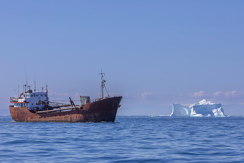 Freighter near iceberg from the nearby Ilulissat Icefjord floating near Ilulissat, Western Greenland, Polar Regions