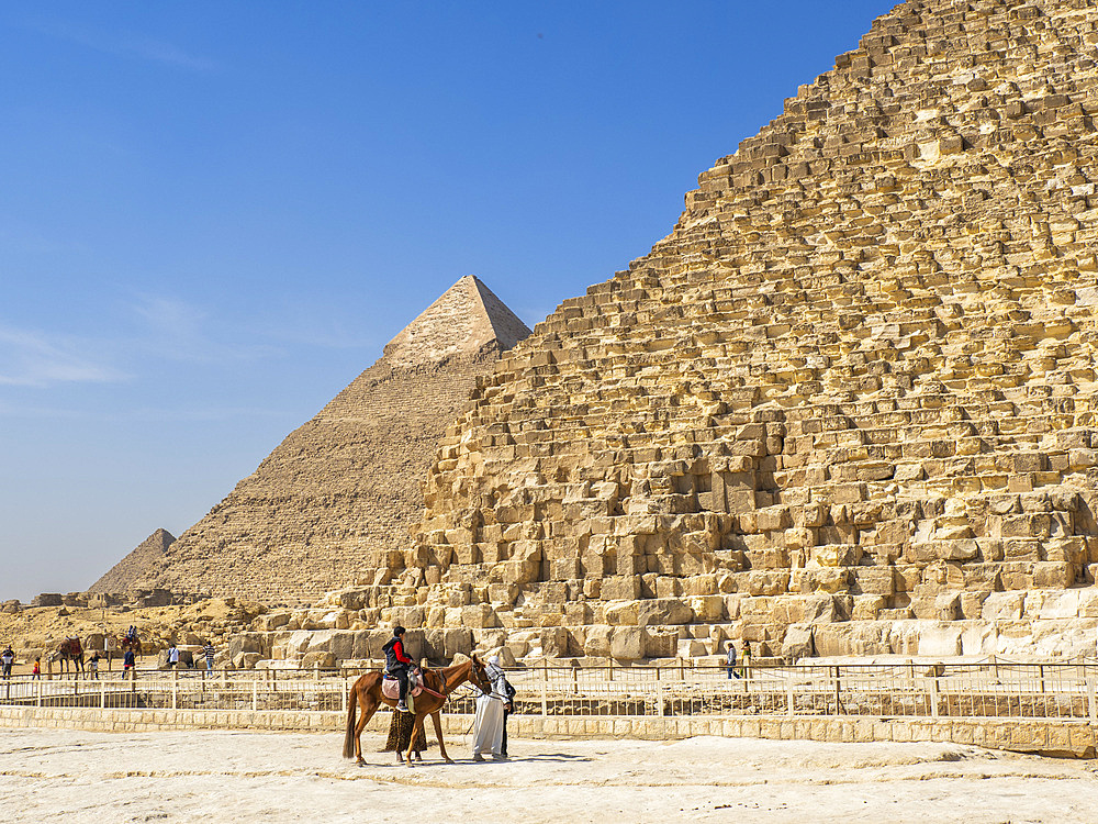 Tourists on camel ride in front of the Great Pyramid of Giza, the oldest of the Seven Wonders of the World, UNESCO World Heritage Site, Giza, near Cairo, Egypt, North Africa, Africa