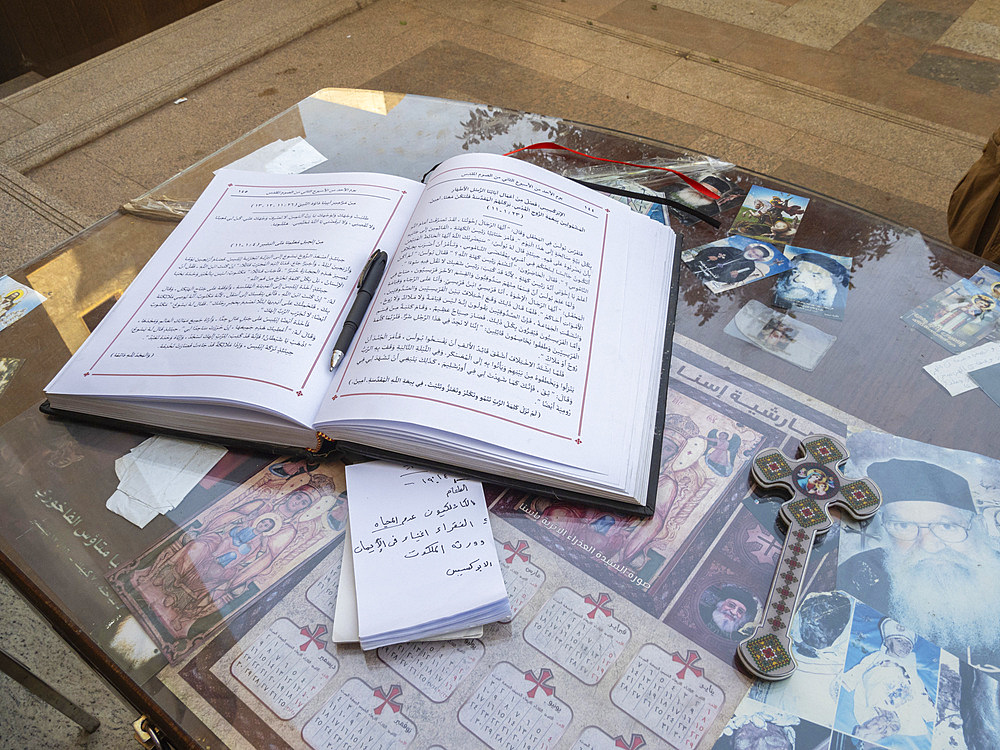 An open ledger book in front of a Catholic Church in the heart of the city of Dendera, Egypt, North Africa, Africa