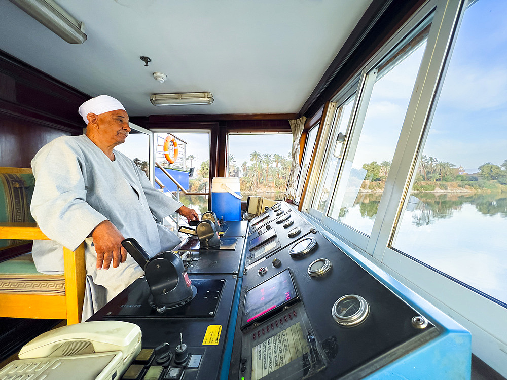 Egyptian Captain of the Oberoi Philae at the helm on the Nile River, Dendera, Egypt, North Africa, Africa