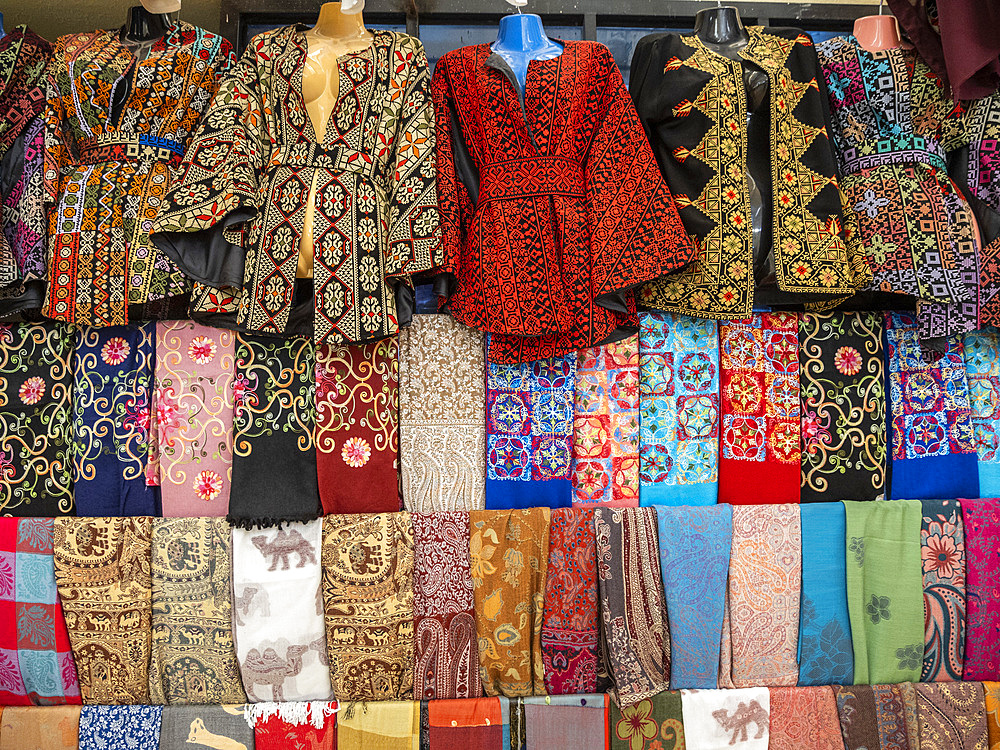 Jackets and colourful fabric for sale in the city of Jerash, Jordan, Middle East