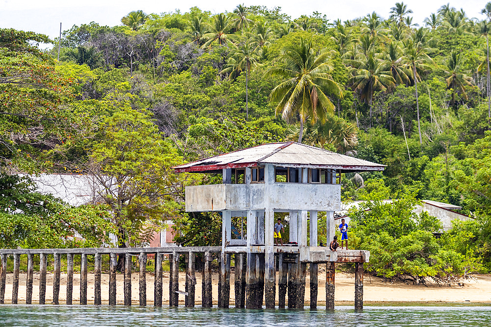 Young men fishing from a local building on Bangka Island, off the northeastern tip of Sulawesi, Indonesia, Southeast Asia, Asia