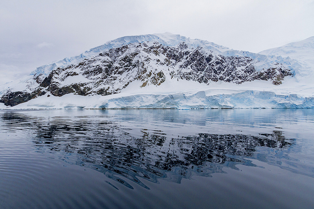 View of calm seas and reflected mountains surrounding Neko Harbor on the western side of the Antarctic Peninsula, Polar Regions