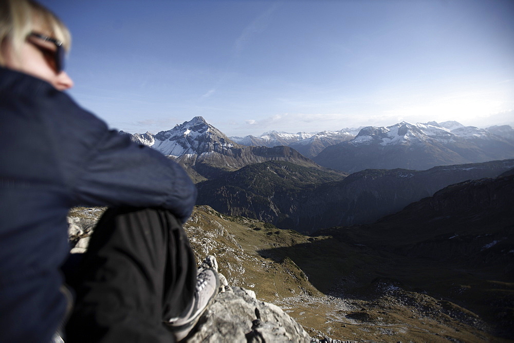 Woman sitting on a rock in the mountains in front of an alp panorama, Oberstdorf, Bavaria, Germany