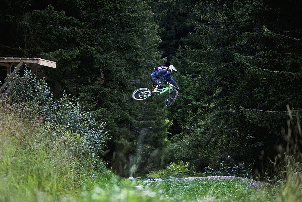 Freeride mountain biker jumping, Chatel, Haute-Savoie, France