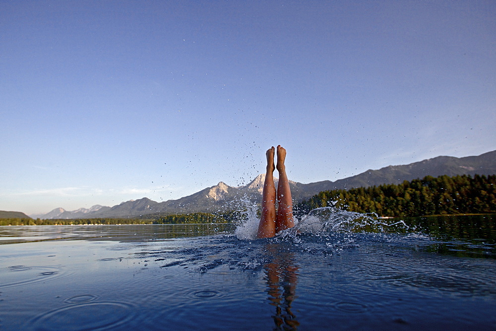 Woman jumping into the Lake Faaker, Alpe-Adria-Trail, Carinthia, Austria