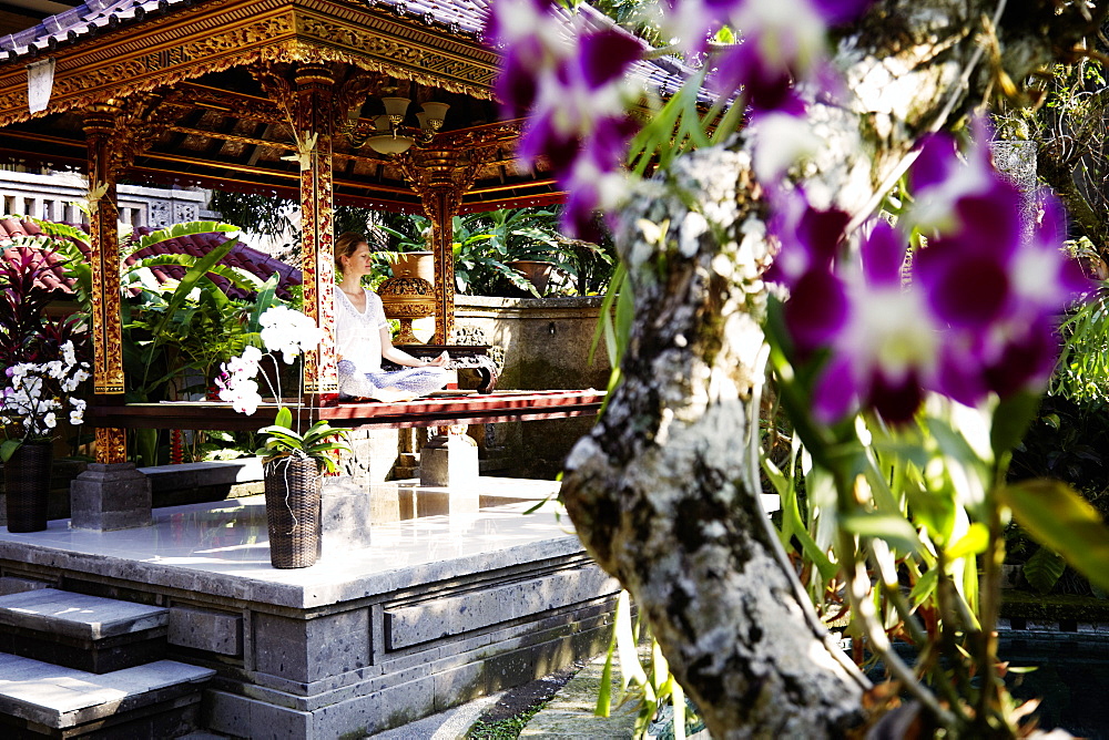 Woman meditating in a pavilion, Ubud, Bali, Indonesia