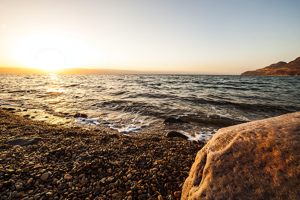 Salt encrusted stone in dead sea at sunset, Jordan, Middle East