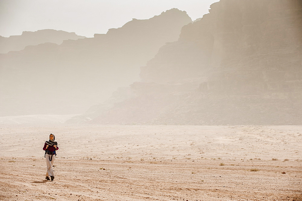 Woman hiking through desert scenery, Wadi Rum, Jordan, Middle East