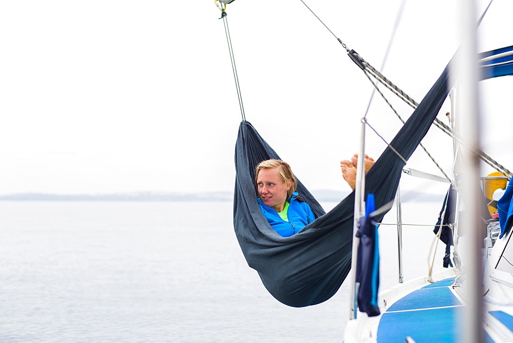 Woman relaxing in a hammock on board of a sailing boat, Pula, Istria, Croatia