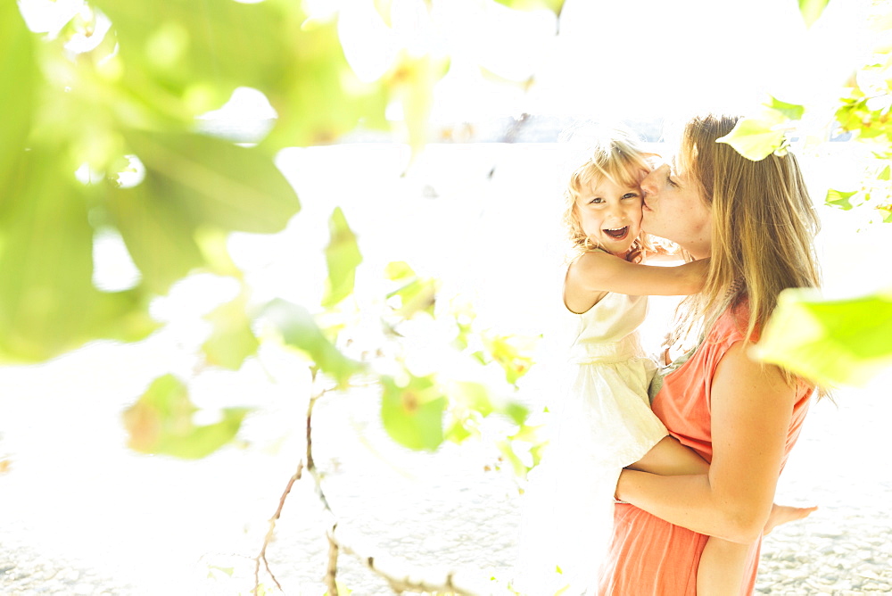 Mother carrying daughter in her arms, lake Starnberg, Berg, Upper Bavaria, Germany