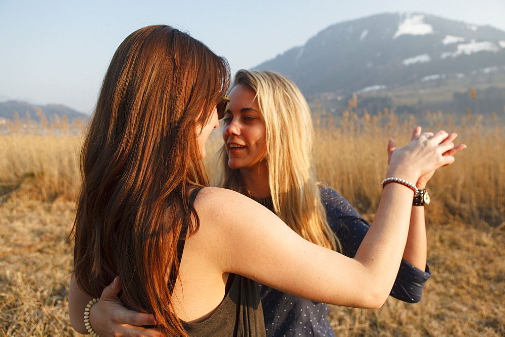 Two young women dancing, Grosser Alpsee, Immenstadt, Bavaria, Germany