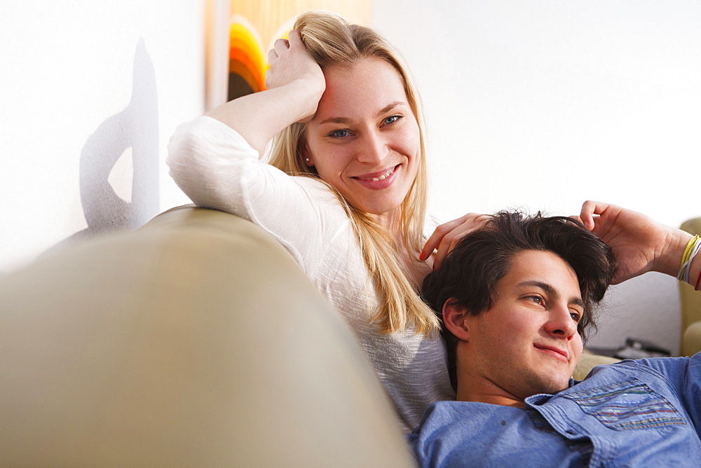 Young couple relaxing on the sofa, Embrassing