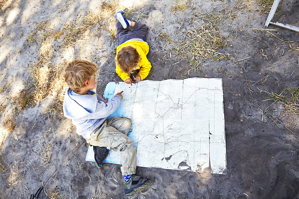 Two boys reading a map, Makgadikgadi Pans National Park, Botswana