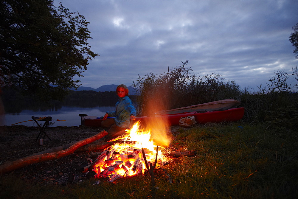 Boy at bonfire, lake Staffelsee, Seehausen, Upper Bavaria, Germany