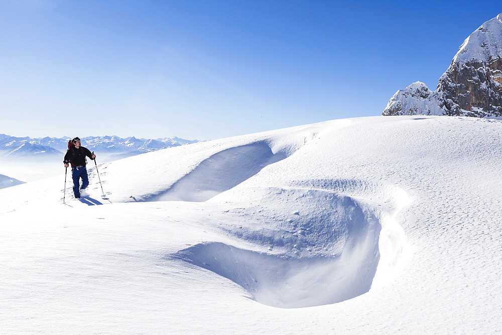 Snowshoe hiker, overlooking Riffl, Tennengebirge mountains, Salzburg, Austria