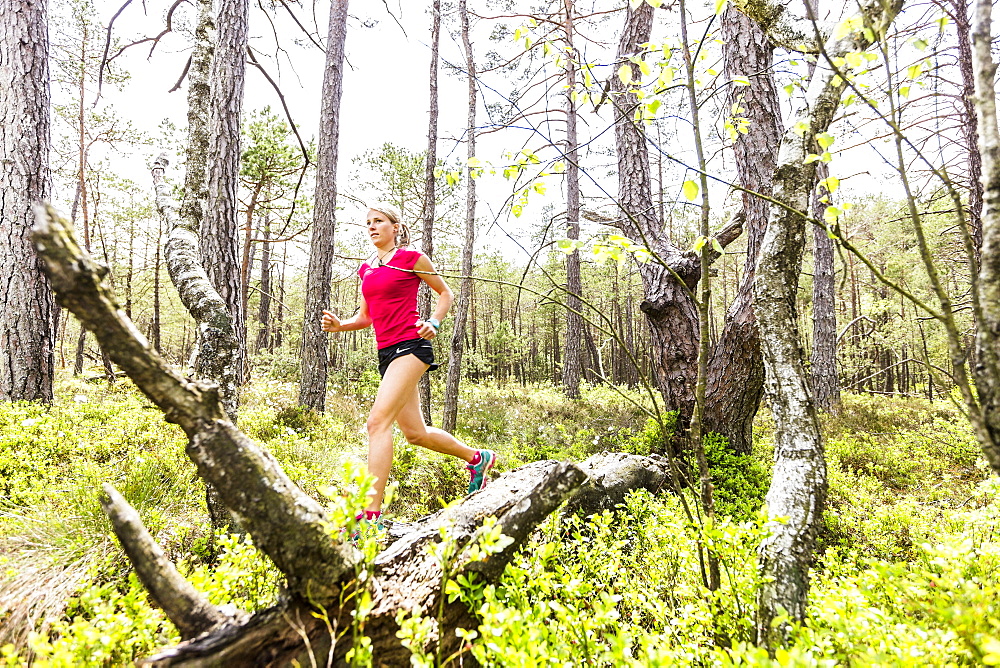 young woman running in a moorland forest, Berg at Lake Starnberg, Upper Bavaria, Germany