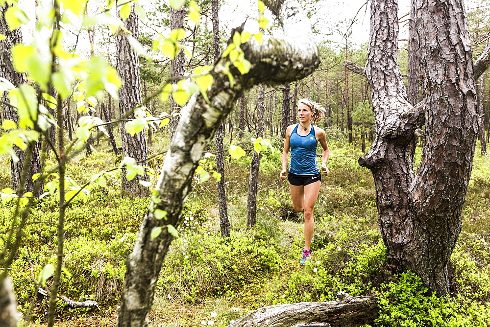 young woman running in a moorland forest, Berg at Lake Starnberg, Upper Bavaria, Germany