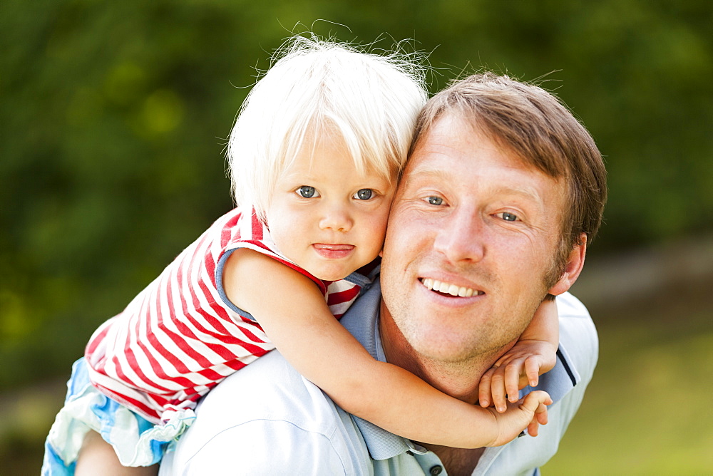 two-year-old girl on her father's back, Speyer, Rheinland-Pfalz, Germany