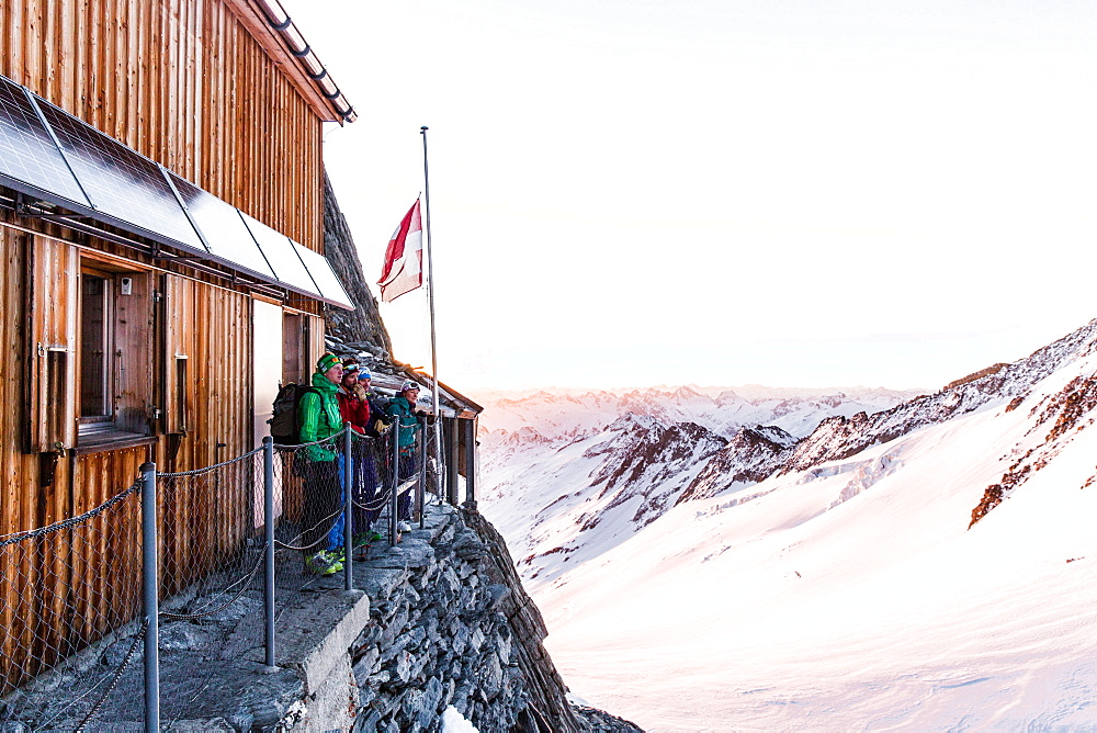 Group standing in front of the Oberaarjoch hut at sunrise, Wallis, Switzerland