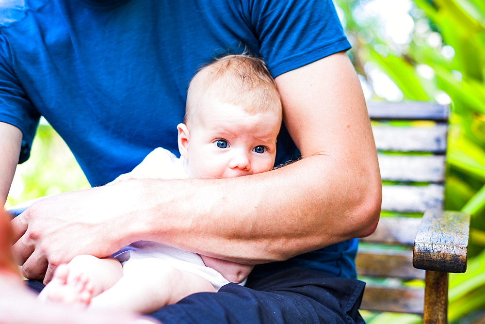 Man holding a baby in his arms, blue eyes, infant, Boipeba, Bahia, Brasil