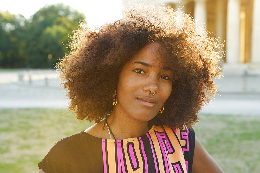 Young afro-american woman in backlight scenery on Koenigsplatz, Munich, Bavaria, Germany