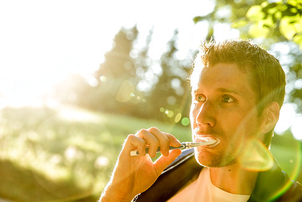 Young male camper brushing his teeth, Freilassing, Bavaria, Germany