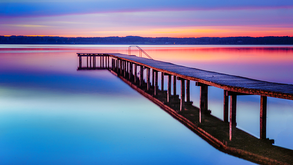 Jetty on Lake Starnberg at sunset with a view of the mountains, St. Heinrich, Bavaria, Germany